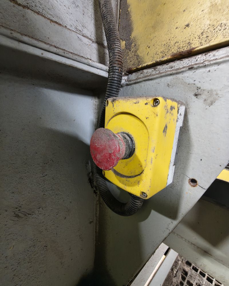 Botão de parada de emergência amarelo instalado em máquina